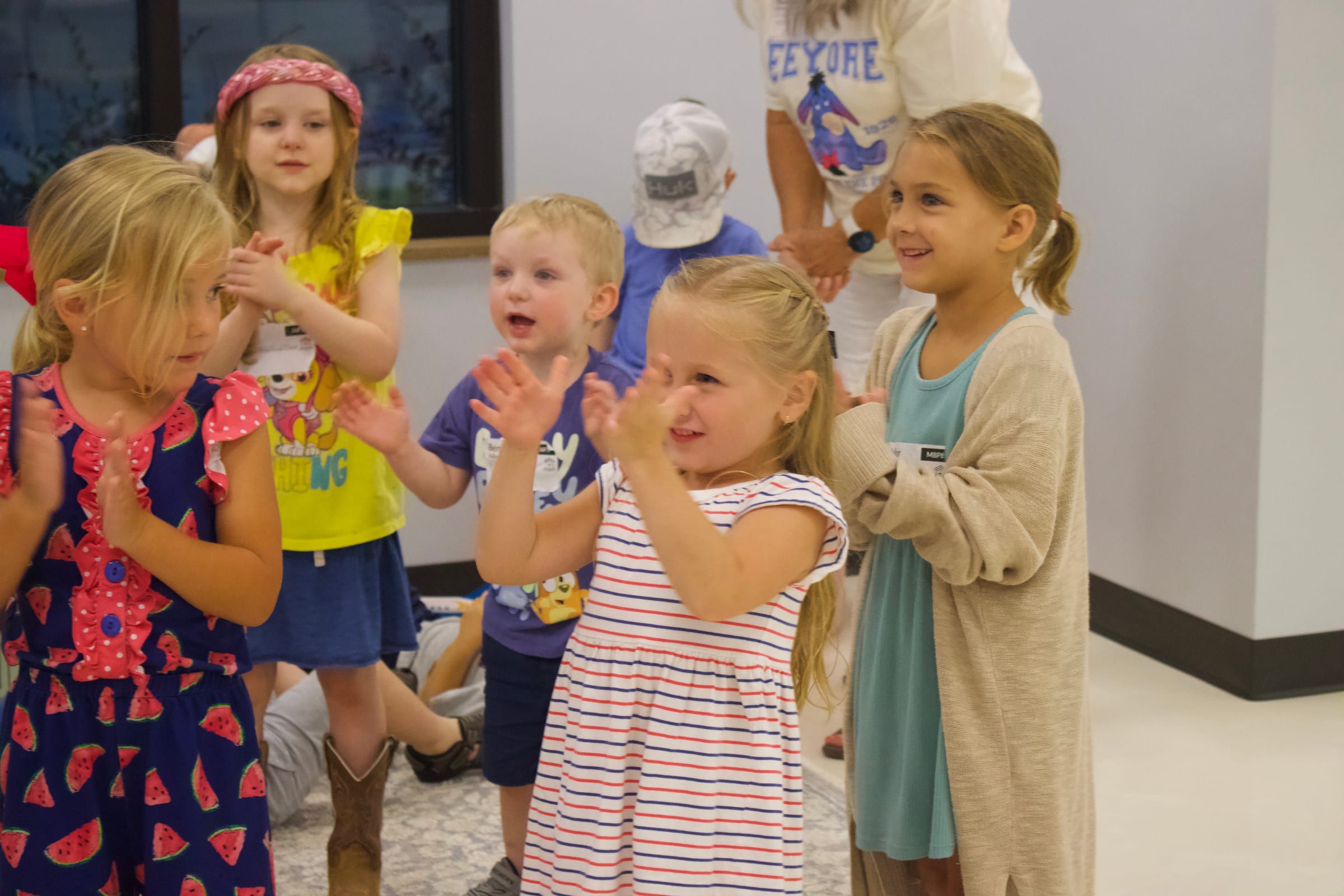 Young children clapping and singing together in a classroom at East Memorial.