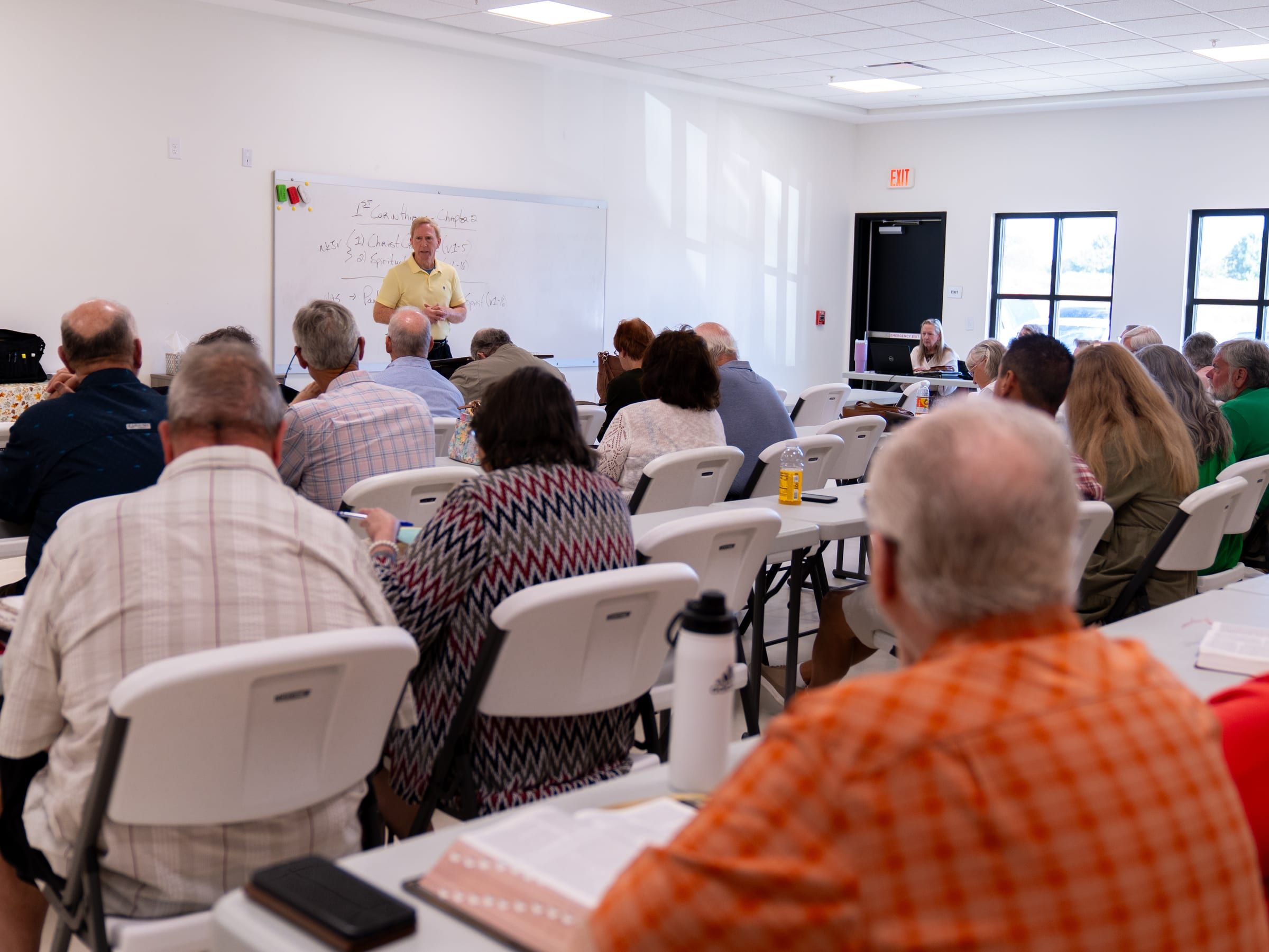 Adults at tables with open Bibles during a Bible study class.