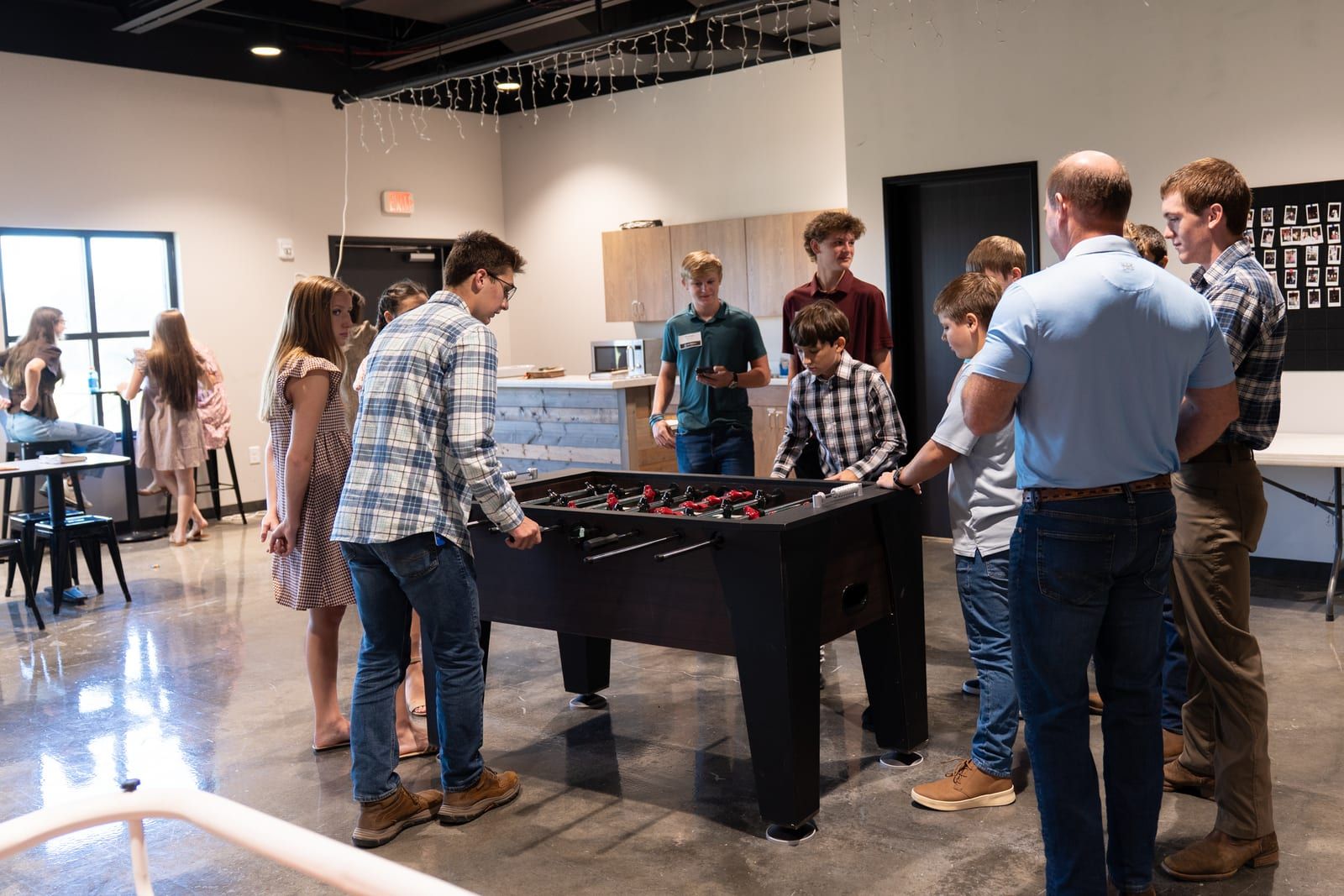 Students playing foosball together in the student ministry room.